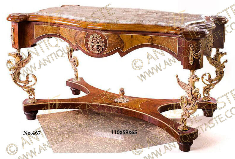 An exceptional and most unique French Louis XV Régence style gilt-ormolu-mounted veneer inlaid coffee table circa 1720, The beveled inset marble top inside a leveled eared frieze adorned with ormolu clasps, above scalloped apron inlaid with double veneer fillet and ornamented with central gilt ormolu flower bouquet cartouche. Each circular curved corner decorated with curtain style gilt ormolu pendant mounts, The apron rests on an elaborate richly chiseled four gilt-ormolu acanthus scrolled griffin head winged mythological creatures legs connected with a concave scalloped veneer inlaid stretcher centered with an ormolu pine cone with foliate base and raised on bun feet, This extraordinary coffee table is part of a set including side tables completing the elegant touch to your place